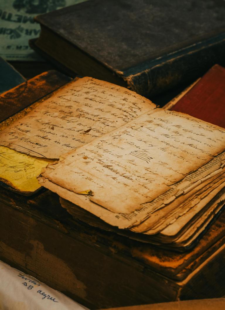 Old paper with cursive writing on a vintage desk, capturing a timeless historical essence.